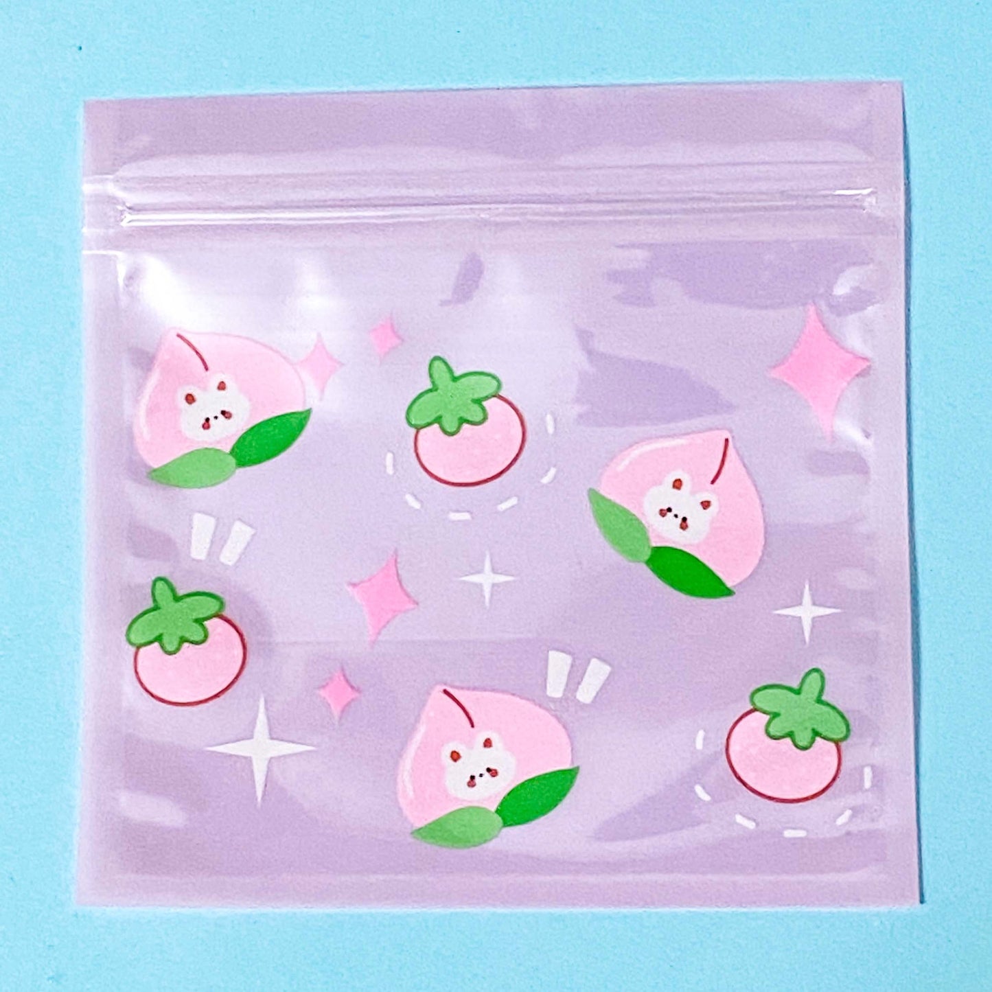Clear plastic bag with pink and green fruit illustrations on a light blue background