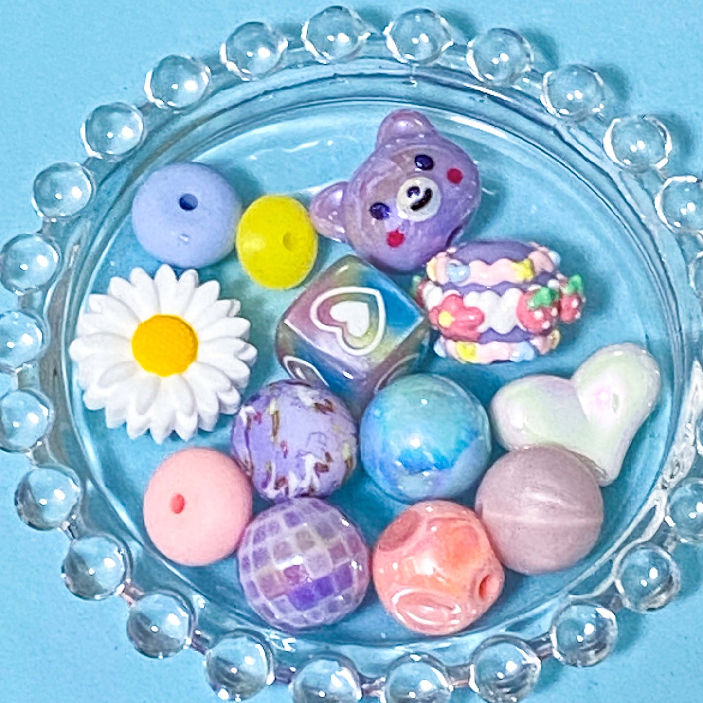 colour themed jumbo acrylic and silicone bead bundle in pastel pink blue and lilac on a blue background