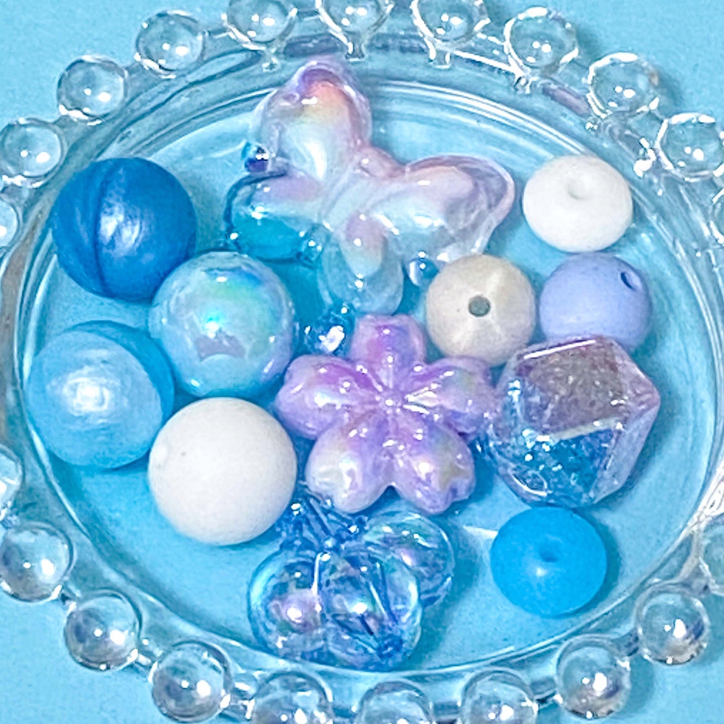 colour themed jumbo acrylic and silicone bead bundle in blue white and lilac on a blue background