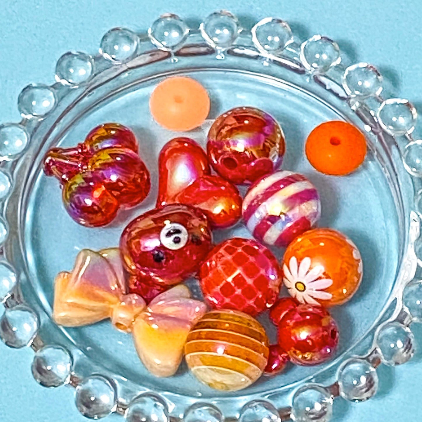 colour themed jumbo acrylic and silicone bead bundle in red and orange on a blue background