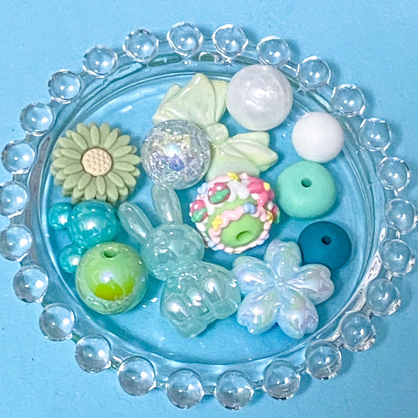 colour themed jumbo acrylic and silicone bead bundle in sage mint and green on a blue background