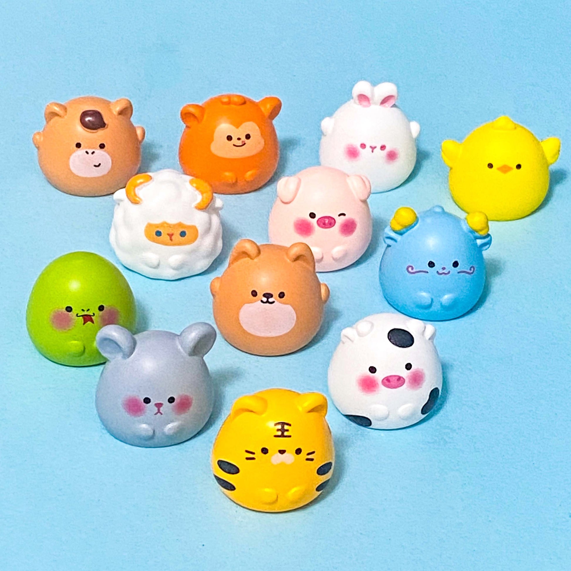 Chinese zodiac animal resin figurines on a blue background