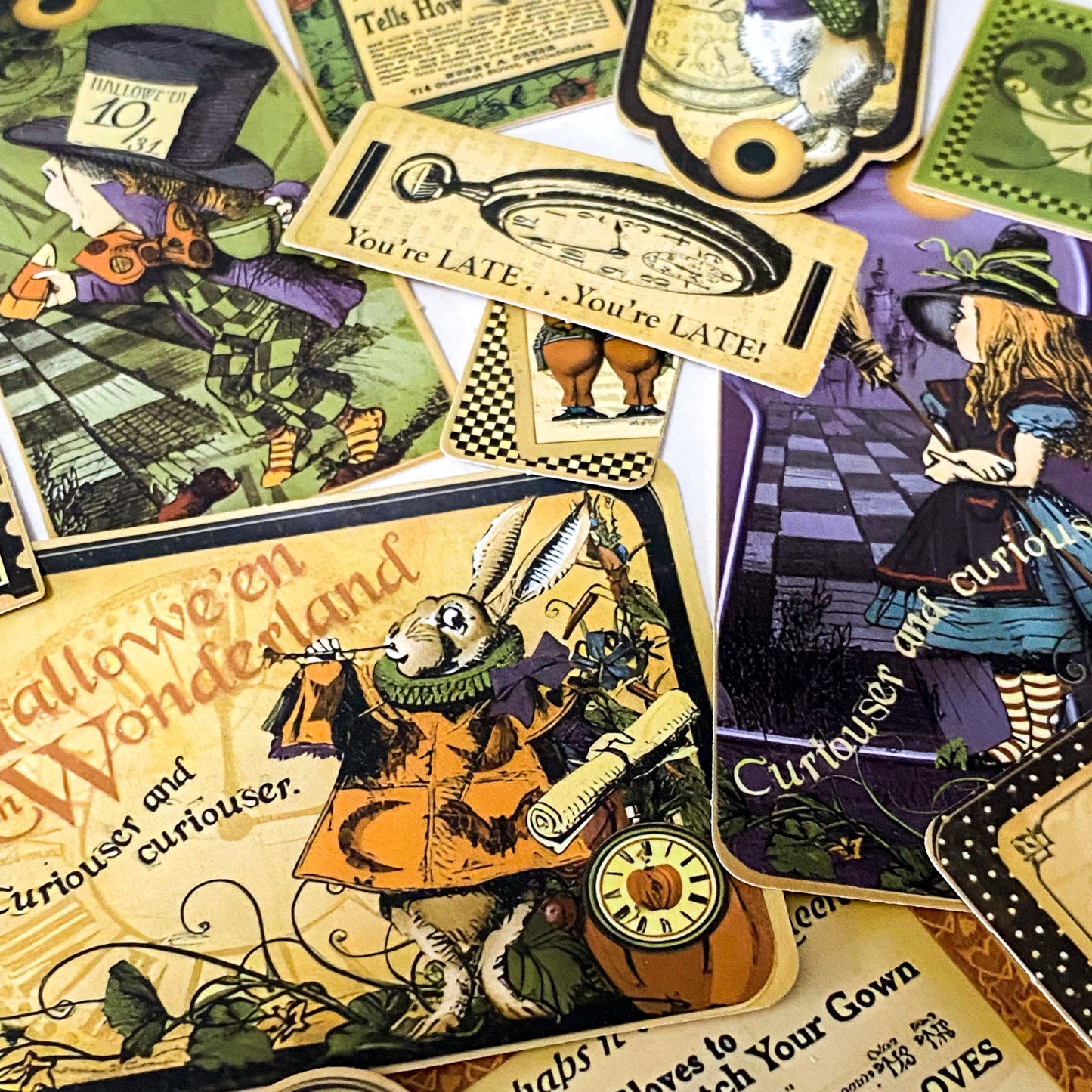 close up of Alice in Wonderland Halloween ephemera stickers featuring mad hatter, clock, pumpkin and vintage tag designs
