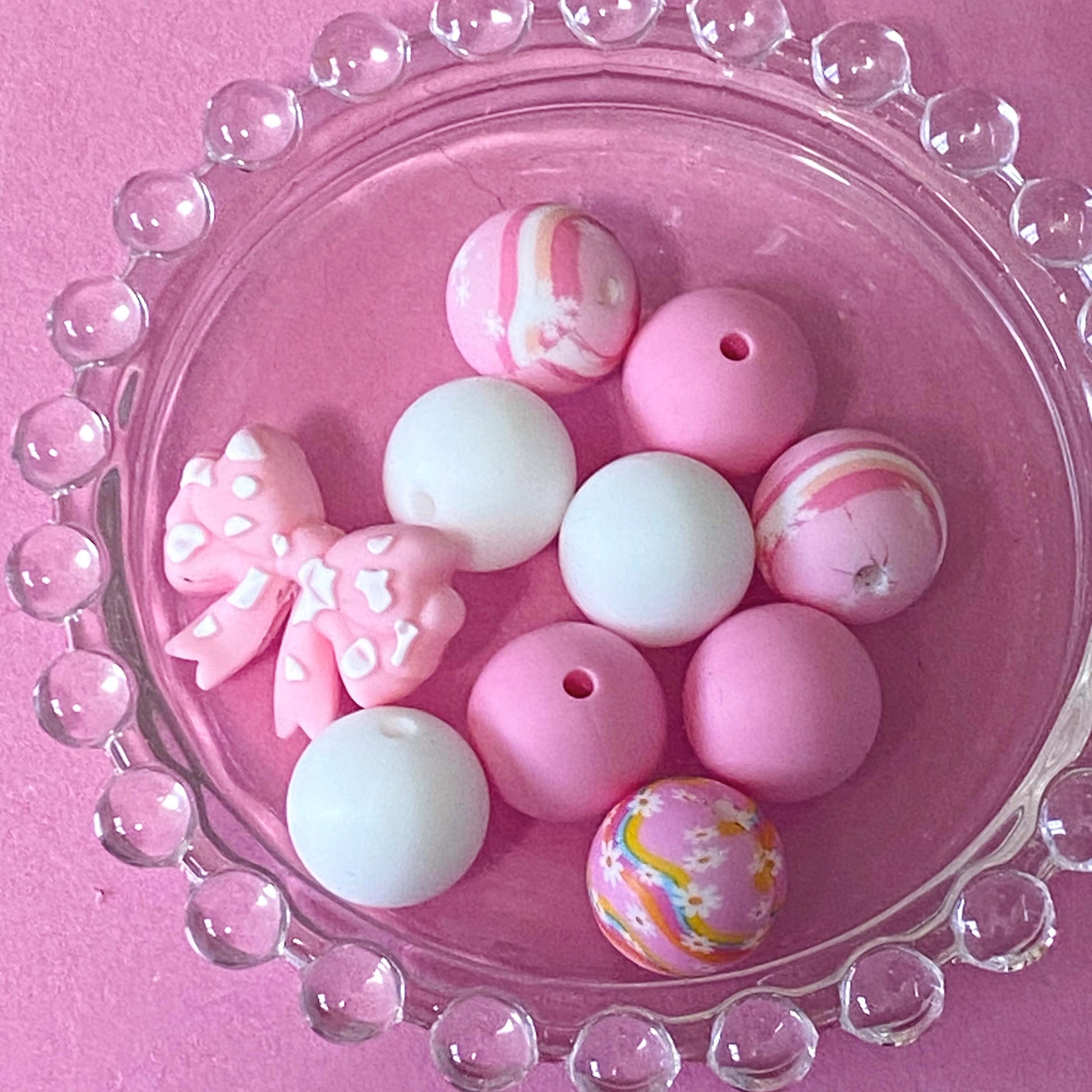 pastel pink silicone bead craft bundles featuring a cute farm black and white cow focal bead or a pink patterned bead with coordinating pink white and floral round silicone beads. uk cute craft supplies shop.