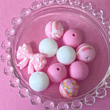 pastel pink silicone bead craft bundles featuring a cute farm black and white cow focal bead or a pink patterned bead with coordinating pink white and floral round silicone beads. uk cute craft supplies shop.