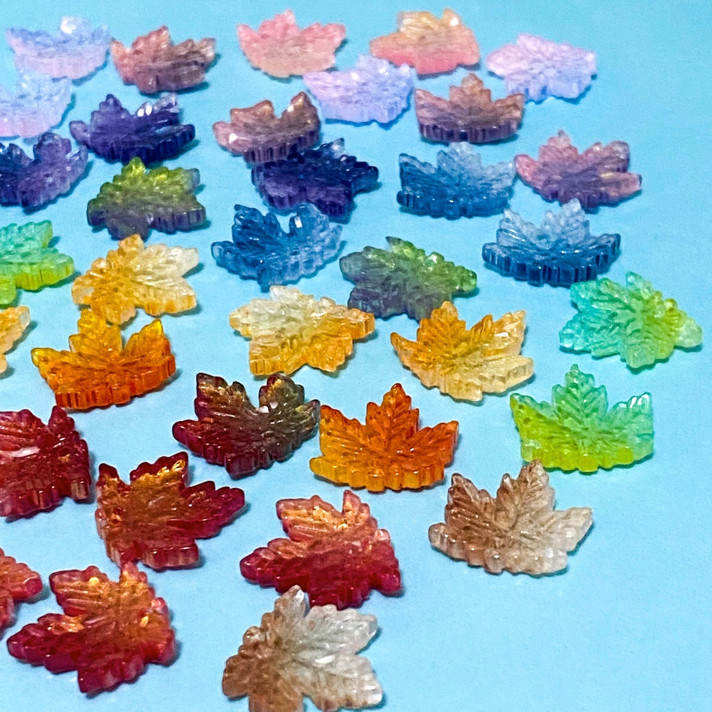 17mm glass maple leaf beads on a blue background
