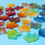 17mm glass maple leaf spacer beads on a blue background