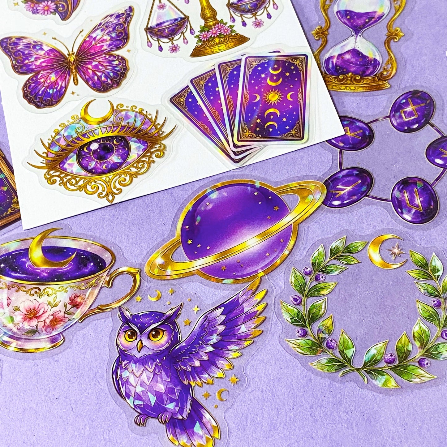 50 different violet oracle witchcore peT stickers featuring crystal balls, tarot cards, butterflies, celestial eyes, candle, owl, skull, moons, potions, flowers, magical purple illustrations. uk stationery gift shop.