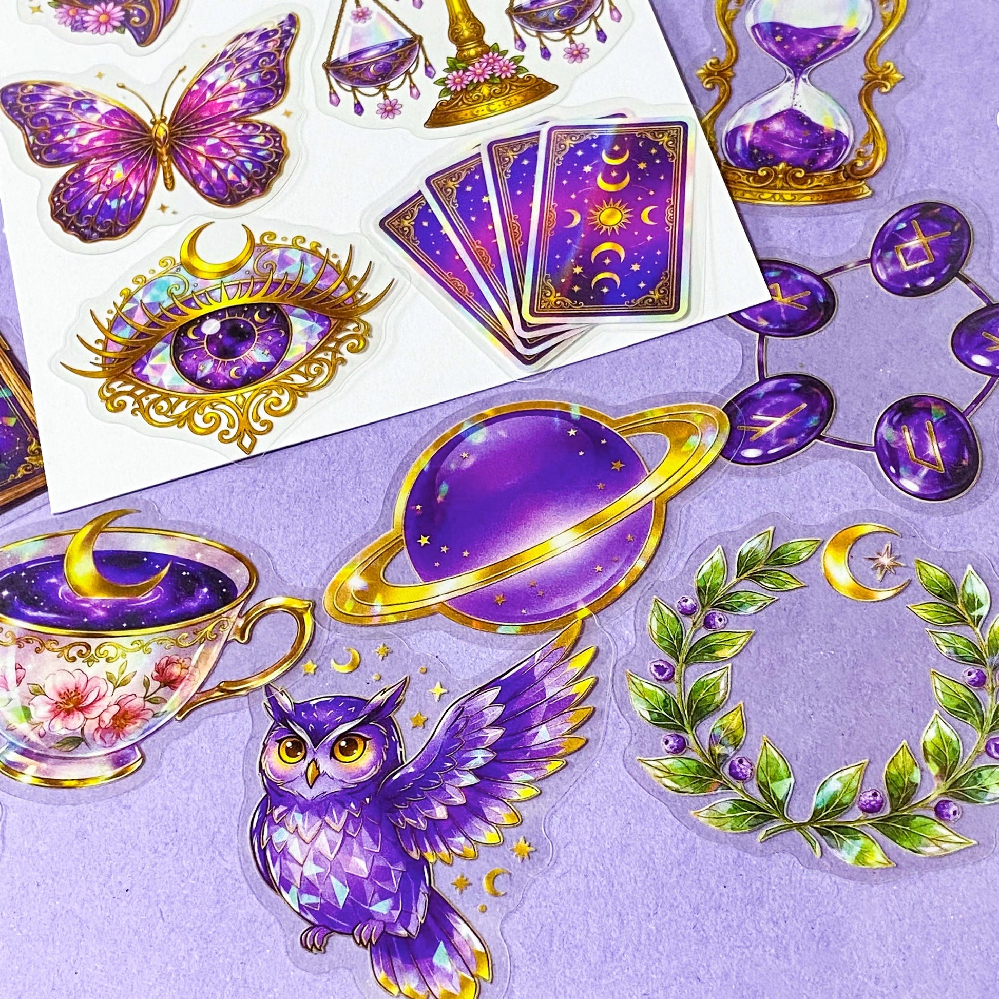 50 different violet oracle witchcore peT stickers featuring crystal balls, tarot cards, butterflies, celestial eyes, candle, owl, skull, moons, potions, flowers, magical purple illustrations. uk stationery gift shop.
