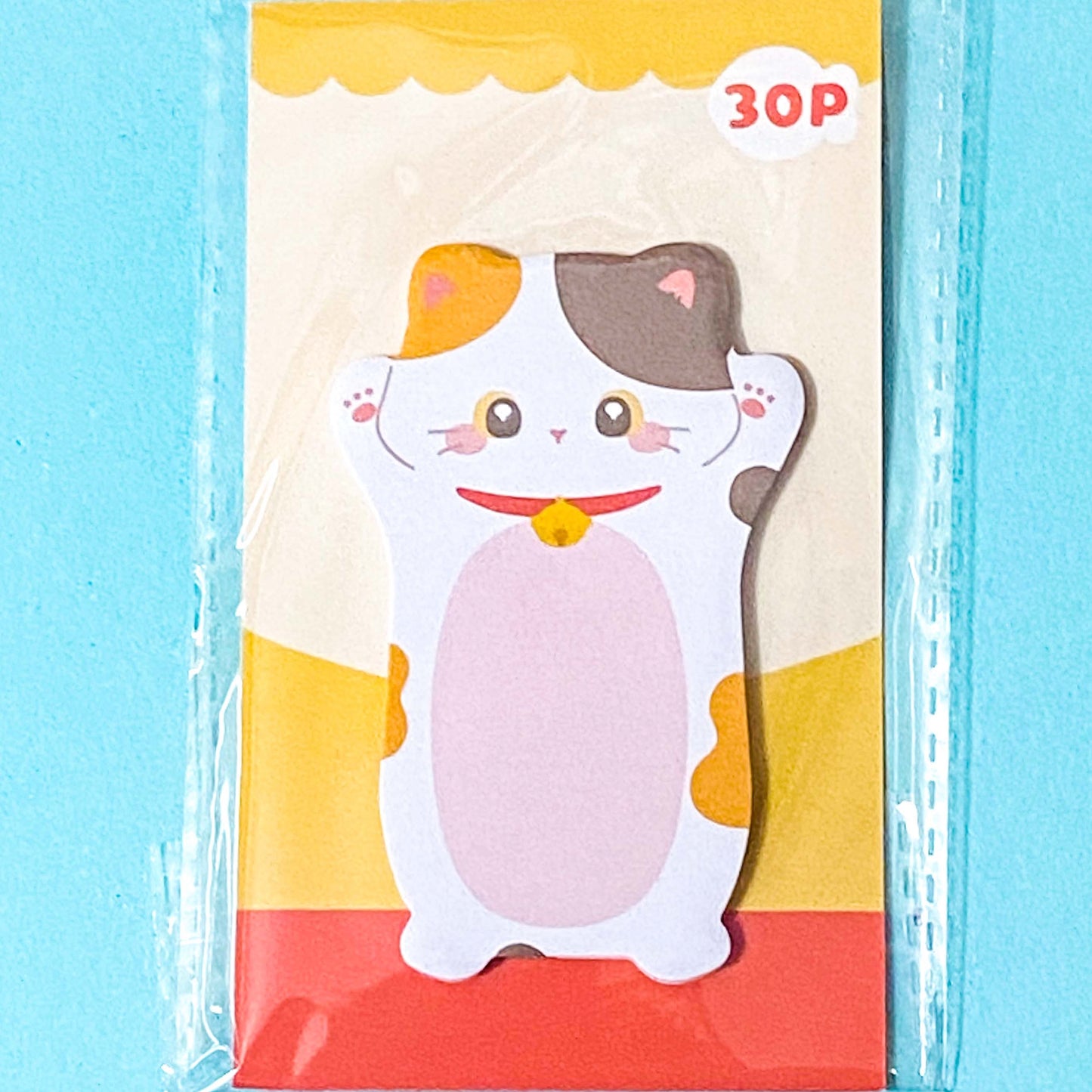 tortoiseshell and white cat sticky note pad on a blue background