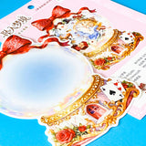 large alice inspired falling into wonderland sticker set with oversized now globe scene card, transparent PET stickers, pocket watch, roses and playing cards details on pink backing card with bow