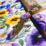 victorian pansy themed letterbox gift set with floral pouch, botanical stickers, vellum journaling sheets and antique style metal and glass bookmark in shades of purple, yellow and blue
