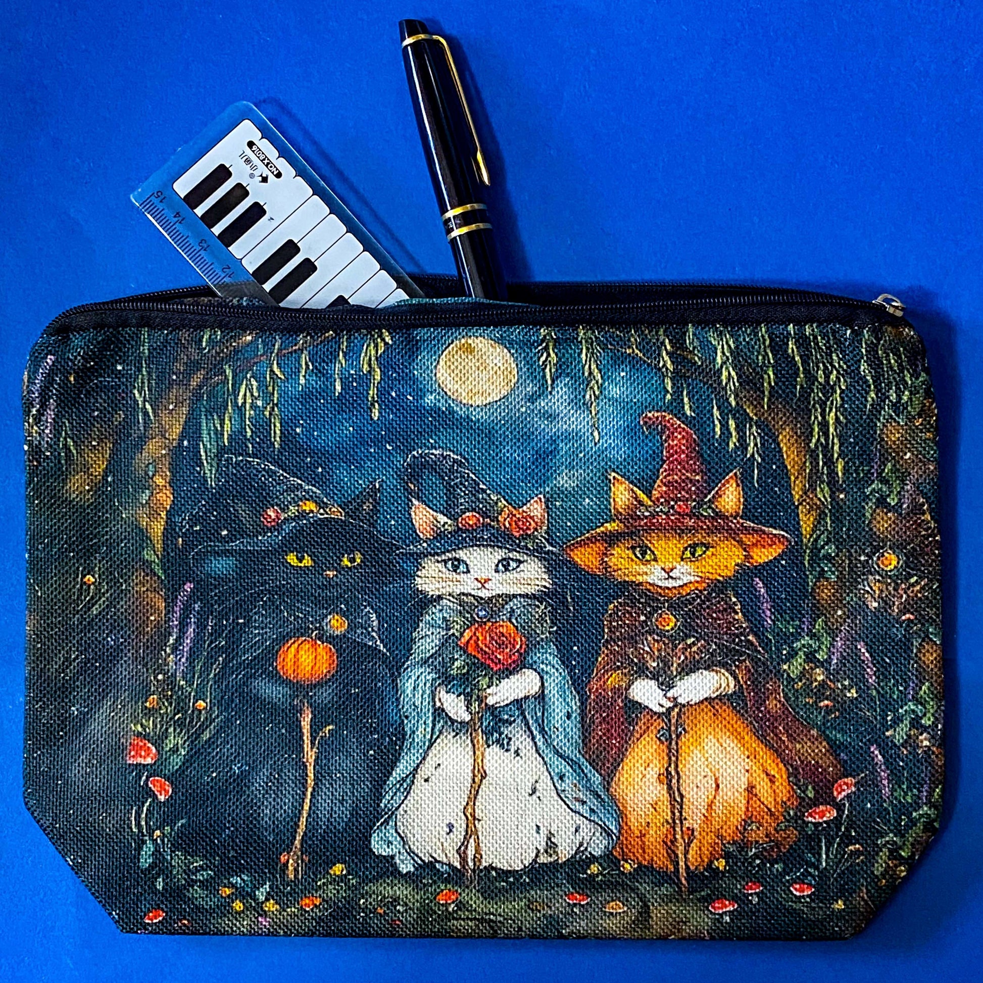 textured canvas pouch featuring three witch cats gathering beneath a full moon in an enchanted woodland with willow branches, mushrooms and autumn leaves. Dark blue, green, storm grey and black. Uk letterbox gifts. Halloween theme.
