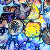 magical woodland witchy laptop stickers with a holographic glow on black on a blue background