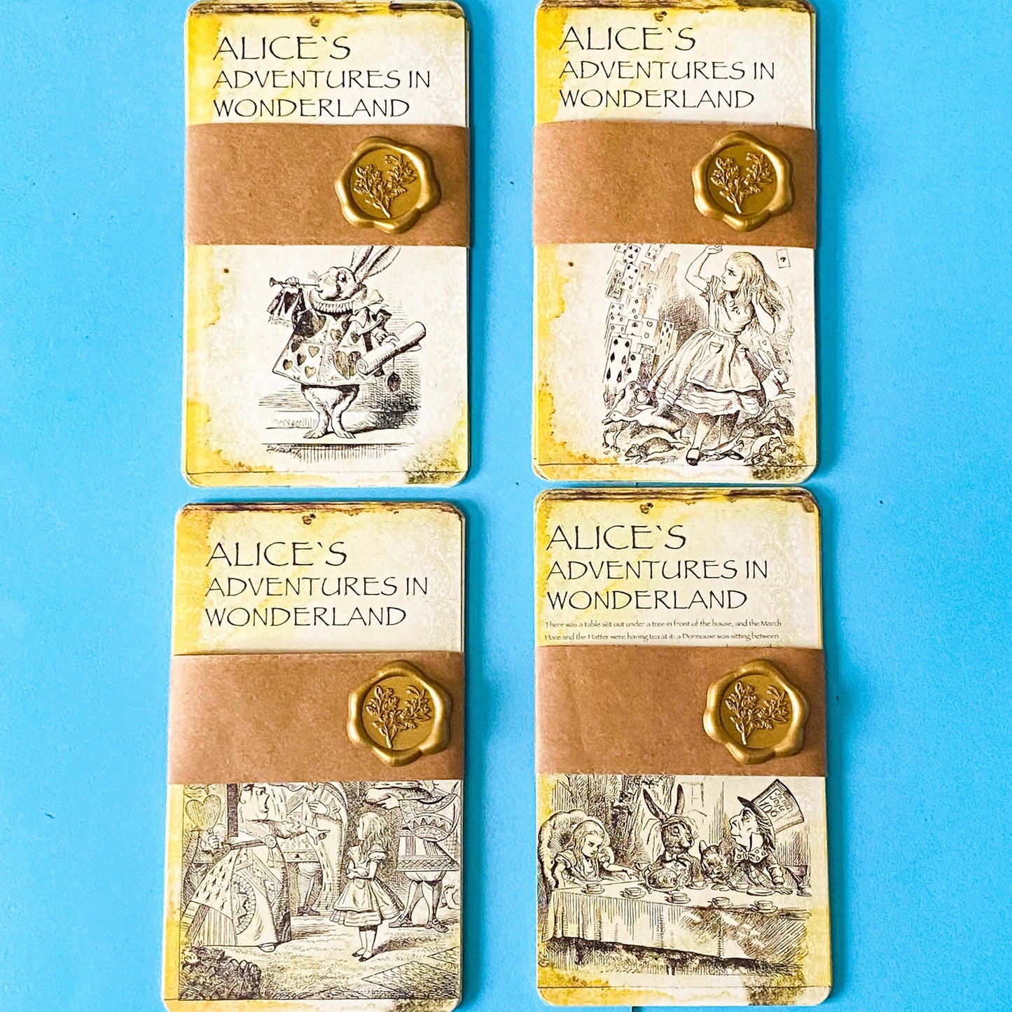 vintage alice in wonderland postcard set with aged sepia parchment illustrations, kraft belly band and wax seal presentation making a beautiful uk letterbox gift