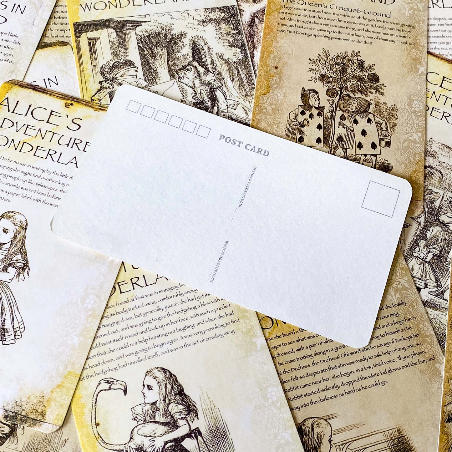 vintage alice in wonderland postcard set with aged sepia parchment illustrations, kraft belly band and wax seal presentation making a beautiful uk letterbox gift