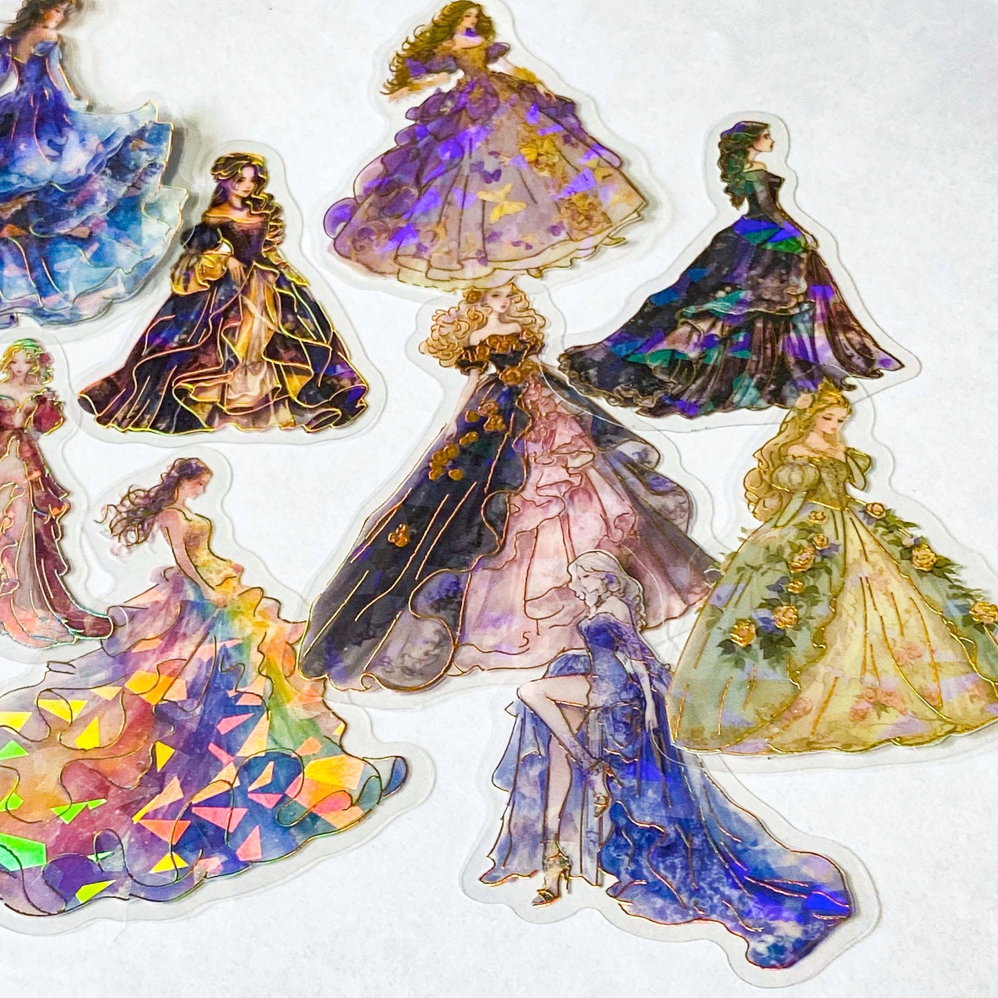 pack of 30 holographic princess stickers with gold foil outlines featuring elegant dancing princesses, castle scenes and fantasy ball gowns on transparent pet plastic clear material. uk cute stationery shop. storybook sticker set.