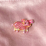 little pink pig sparkly rhinestone pink glittery enamel and gold tone metal brooch on a velvet bag