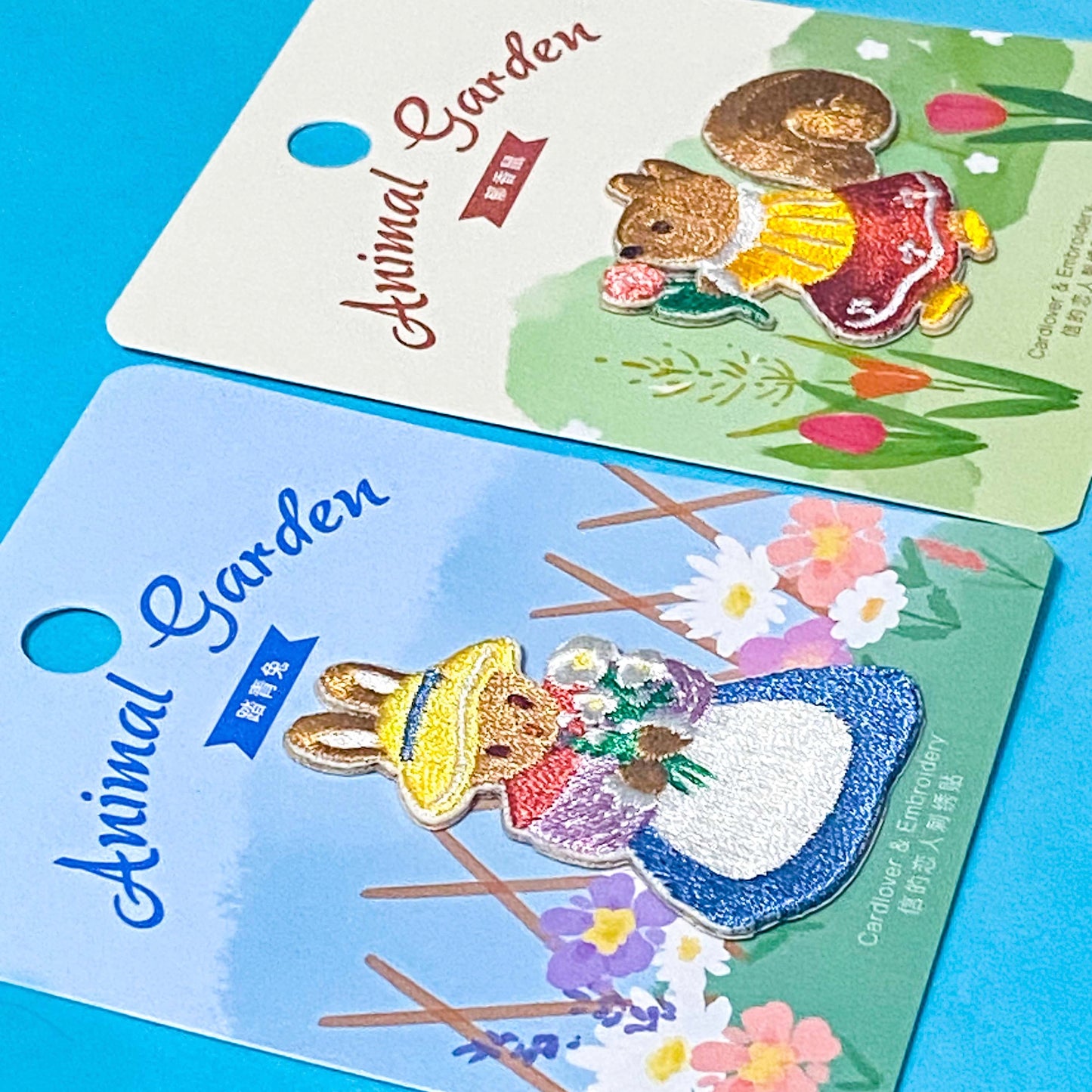 two animal embroidered fabric iron on patches of a squirrel and a rabbit on a blue background