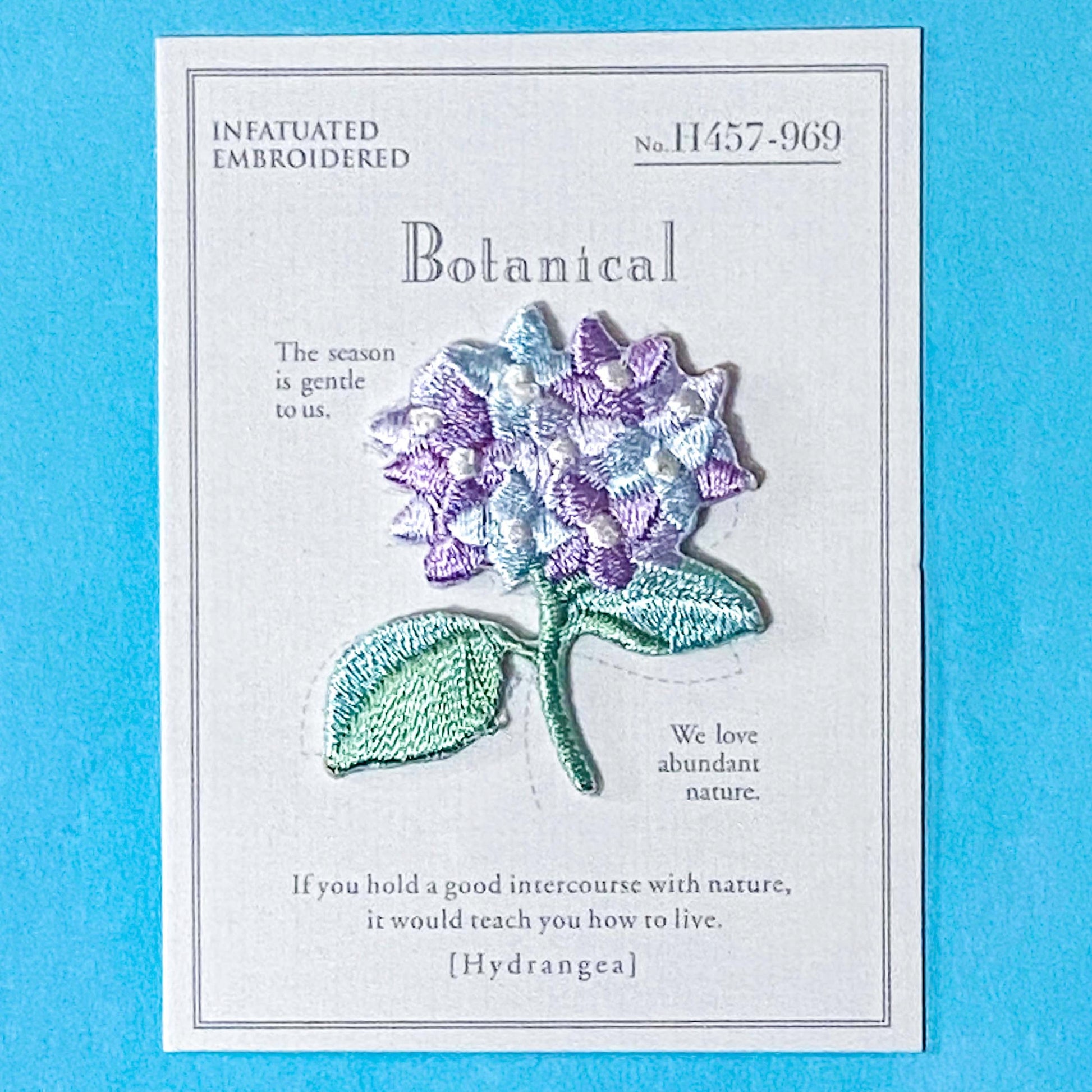 hydrangea embroidery iron on patch on a blue background