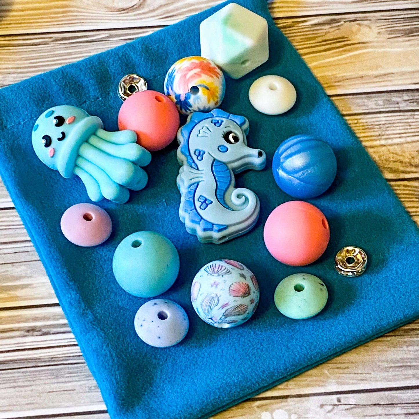 ocean silicone beads set of 15 with seahorse and octopus focal beads and round and multi sided aqua, teal, turquoise, pink and blue beads to make a beaded pen