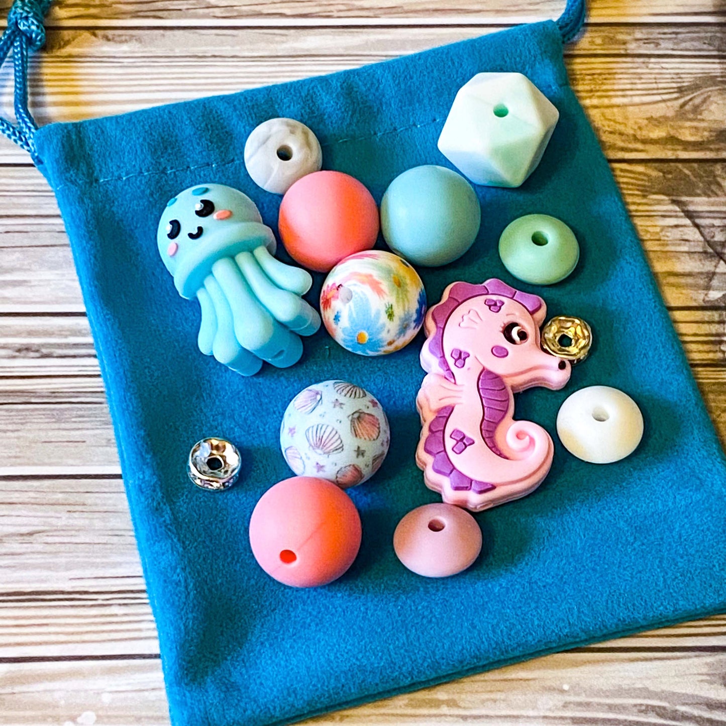 ocean silicone beads set of 15 with seahorse and octopus focal beads and round and multi sided aqua, teal, turquoise, pink and blue beads to make a beaded pen