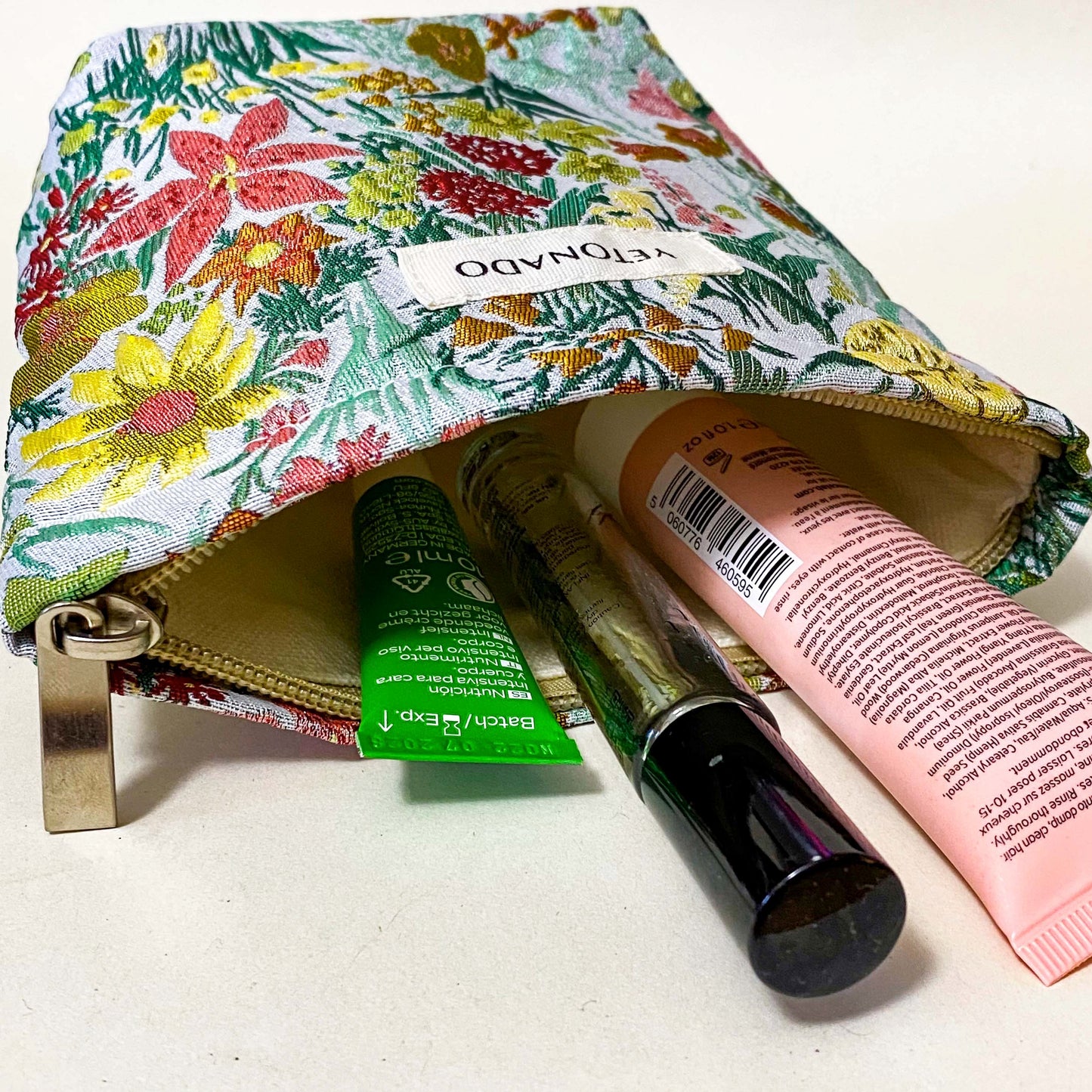 premium woven green, peach and yellow wild flower tapestry small bucket pouch with cream lining and concealed zip. Uk letterbox gifts. Botanical cosmetic bag.