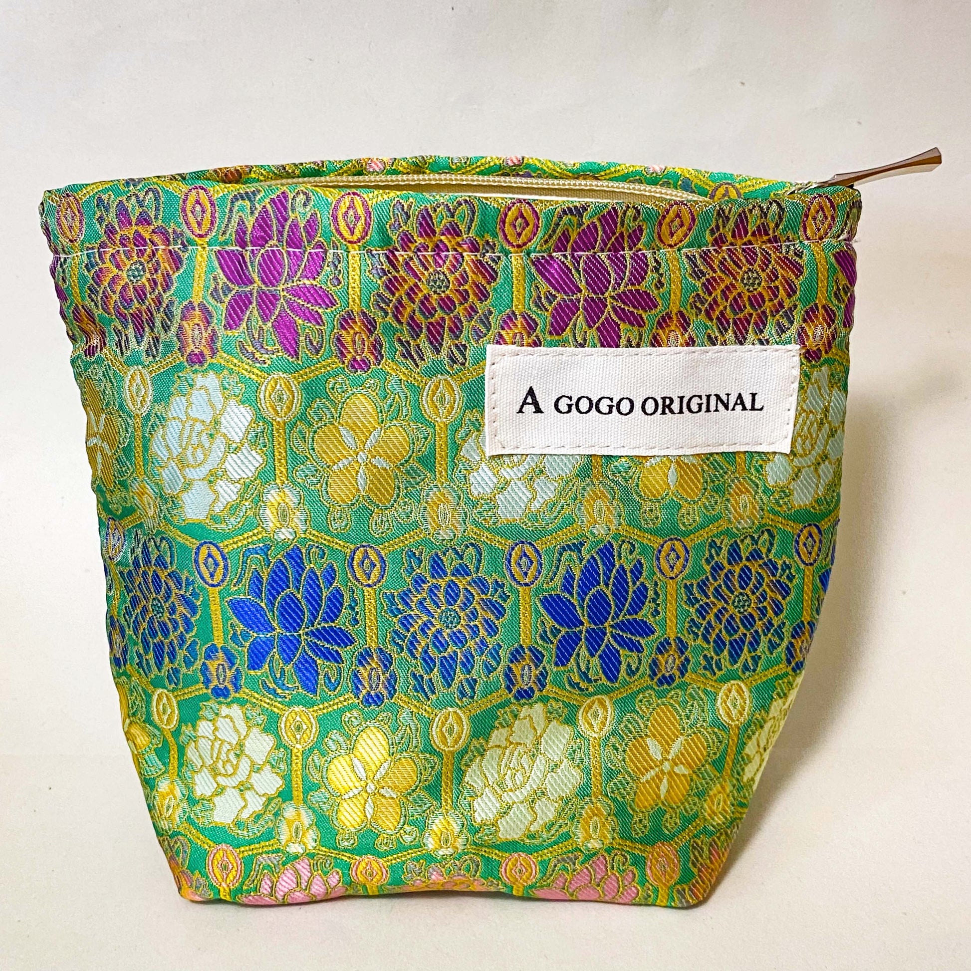 premium woven brocade cosmetic pouch in jade green with intricate mosaic inspired pattern in blue, purple, antique gold and cream. Fully lined with concealed zip. UK letterbox gifts shop. Small ornate fabric make up bag. 