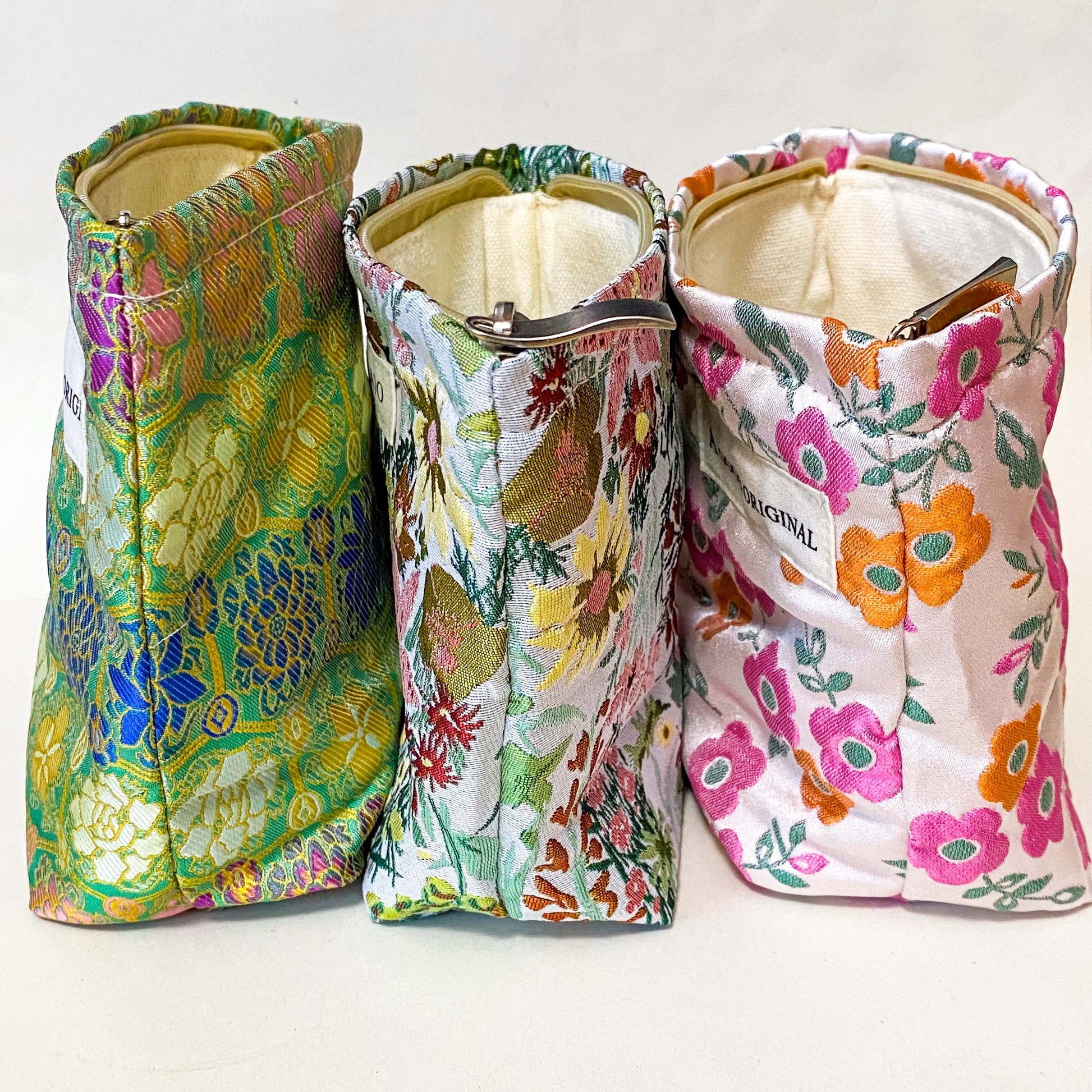 premium woven retro blossom lane cosmetic pouch with pink and coral orange floral design, cream lining and concealed zip. Small bucket shape make up bag. uk letterbox gifts for flower lovers.