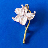 Floral iris silvery lilac enamel brooch with gold stem on a blue background