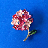 Floral hydrangea brooch with pink and red flowers on a blue background