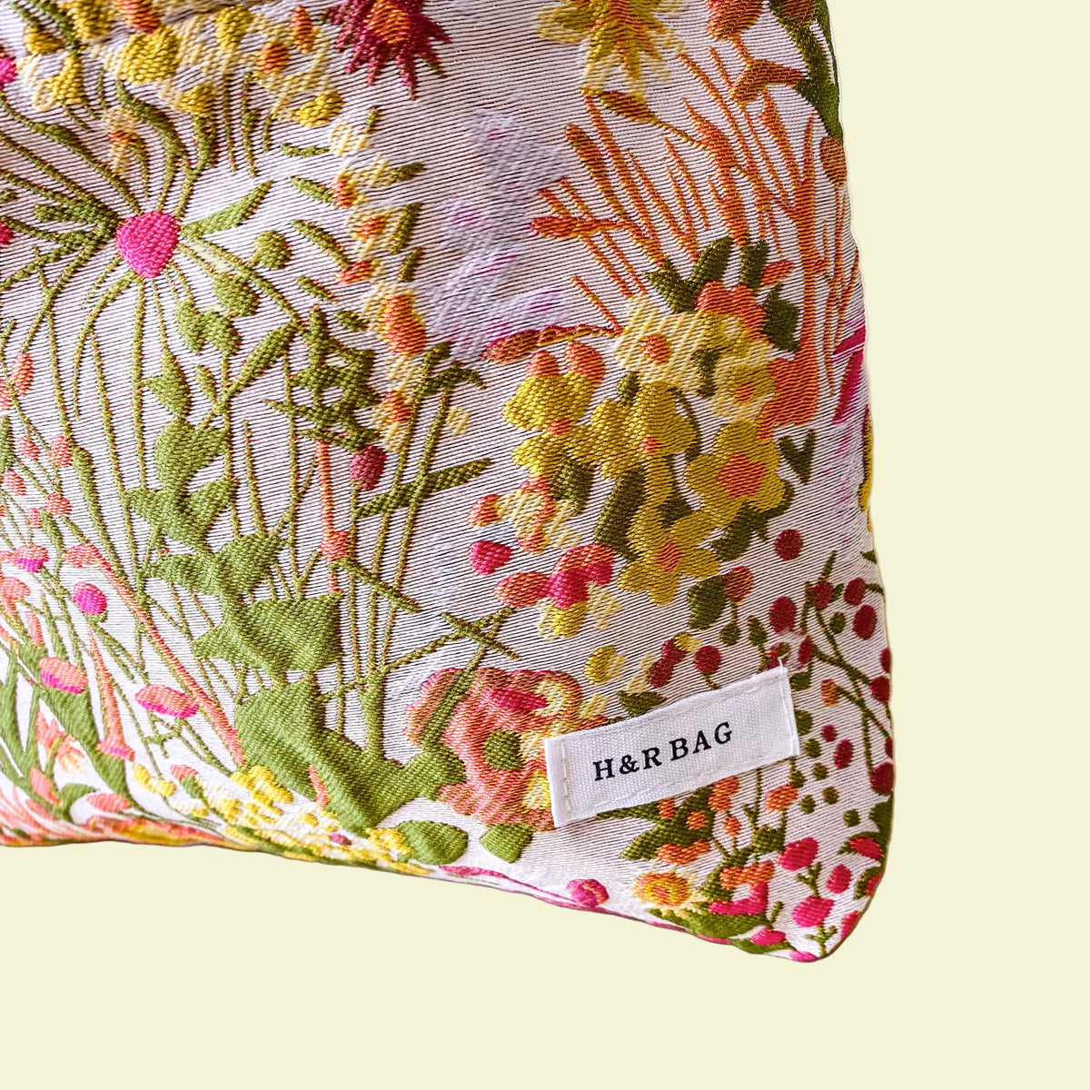 wildflower meadow tapestry pouch with colourful woven floral design including daisies, cream lining, concealed zip closure and gusseted base. Cream, orange, lemon, soft green and white design. Subtle sheen. Large cosmetic bag or toiletry pouch. Uk botanical gift shop.