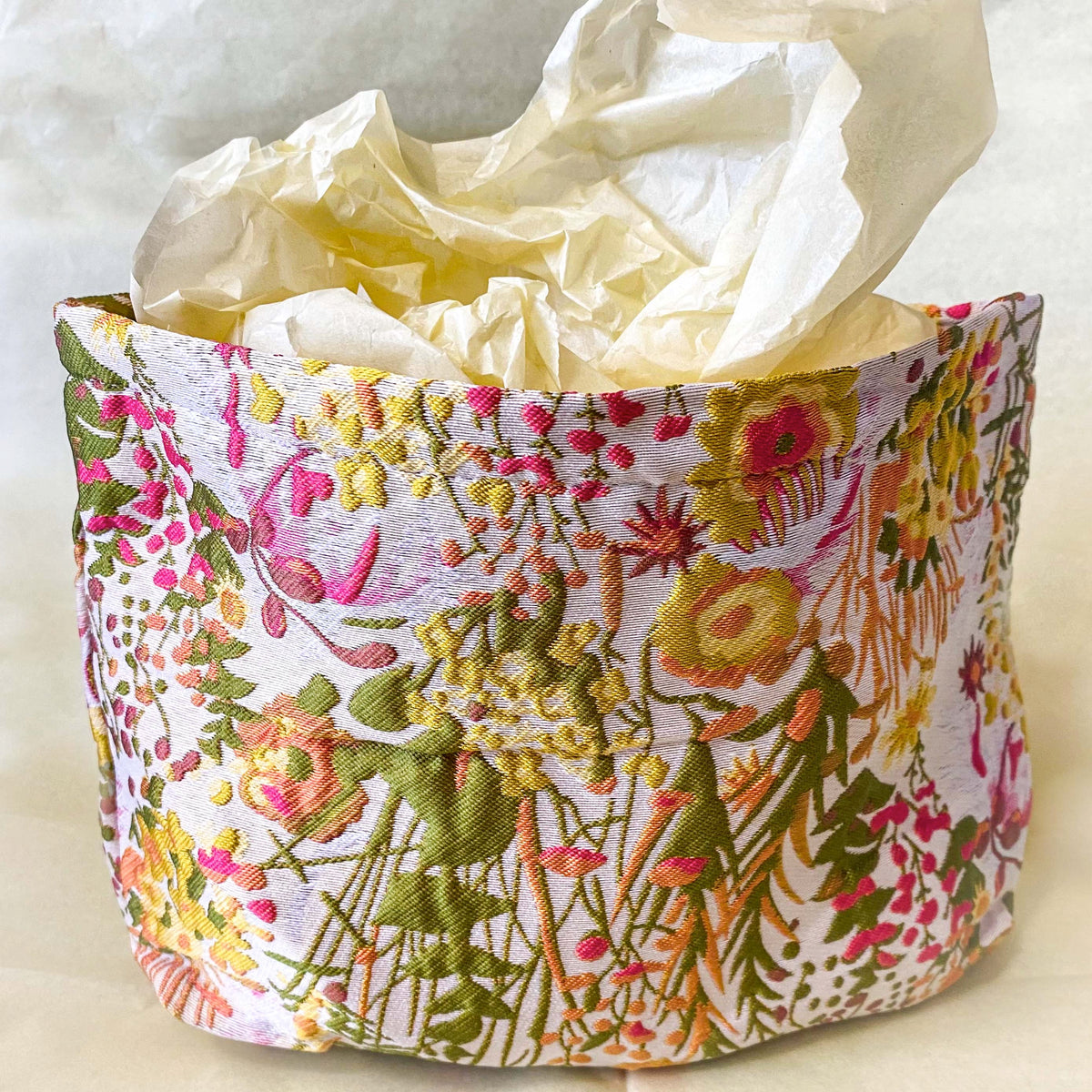 wildflower meadow tapestry pouch with colourful woven floral design including daisies, cream lining, concealed zip closure and gusseted base. Cream, orange, lemon, soft green and white design. Subtle sheen. Large cosmetic bag or toiletry pouch. Uk botanical gift shop.