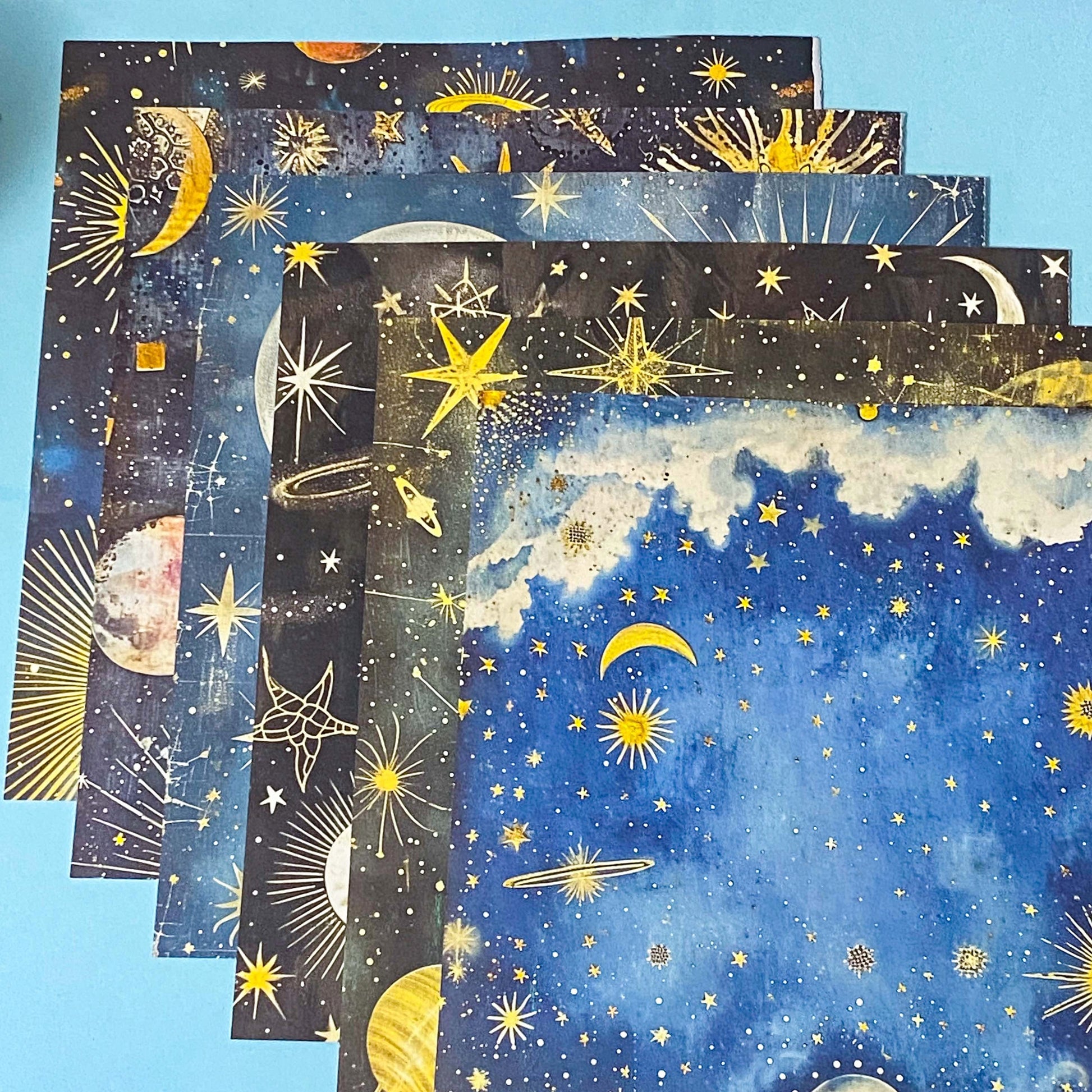 celestial scrapbook paper pack with dark blue sky night designs featuring gold stars, moons, planets and vintage astrology illustrations