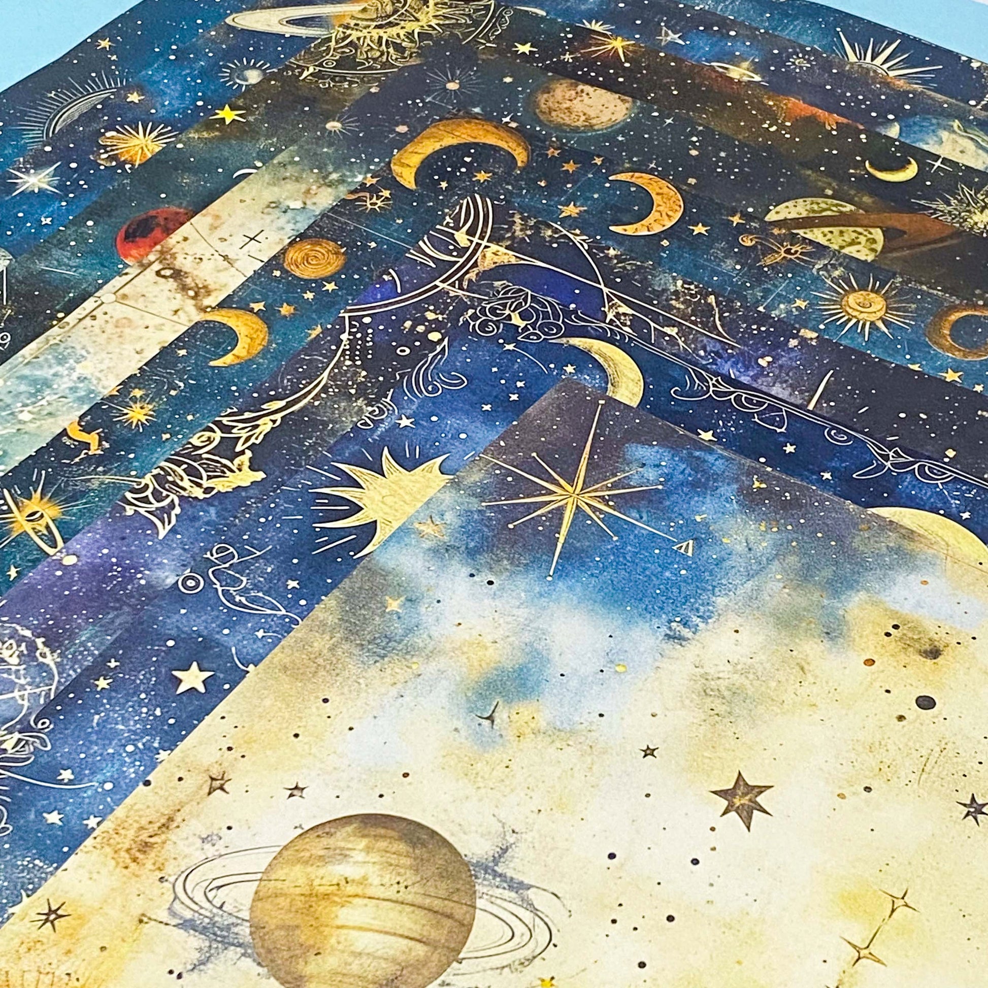 celestial scrapbook paper pack with dark blue sky night designs featuring gold stars, moons, planets and vintage astrology illustrations