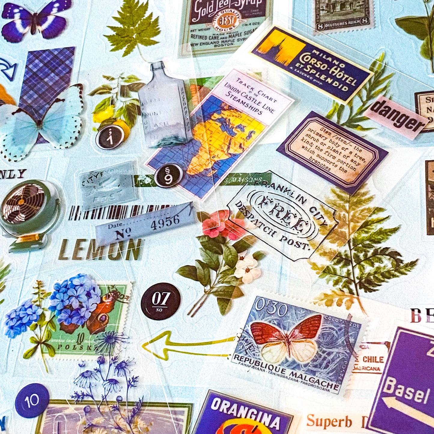 pack of 25 clear sticker sheets in blue and green theme featuring vintage butterflies, postage stamps, flowers, plants and retro packaging of products labels