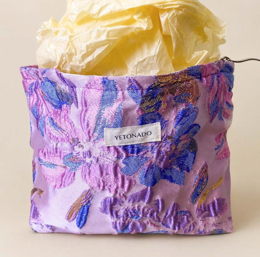 Elegant satin-finish tapestry pouch featuring woven lavender and blue florals with gold metallic thread, cream lining, concealed zip and gusseted base. Ideal for cosmetics and stationery