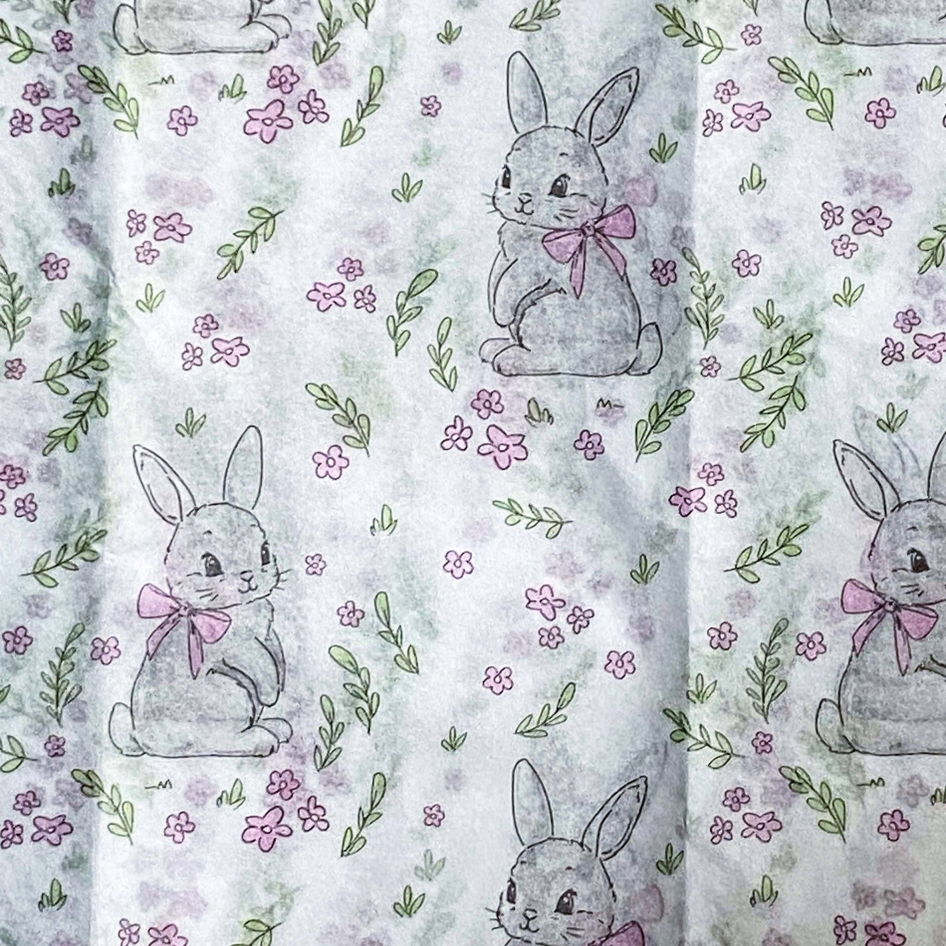 tissue paper with a pattern of grey bunnies with pink bows on a floral background