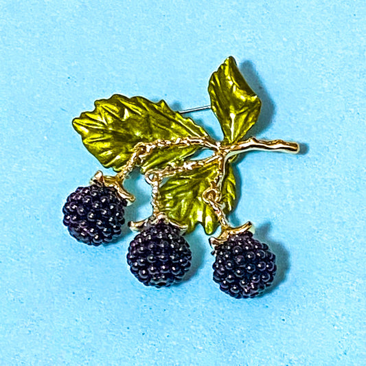 articulated blackberries and leaves enamel metal brooch on a blue background