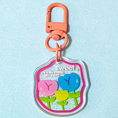Keychain with colourful tulip flowers and 'sweet' text on a light blue background