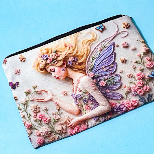 fairy garden canvas zip pouch with floral illustration and butterfly wings used as a pencil case on a blue background