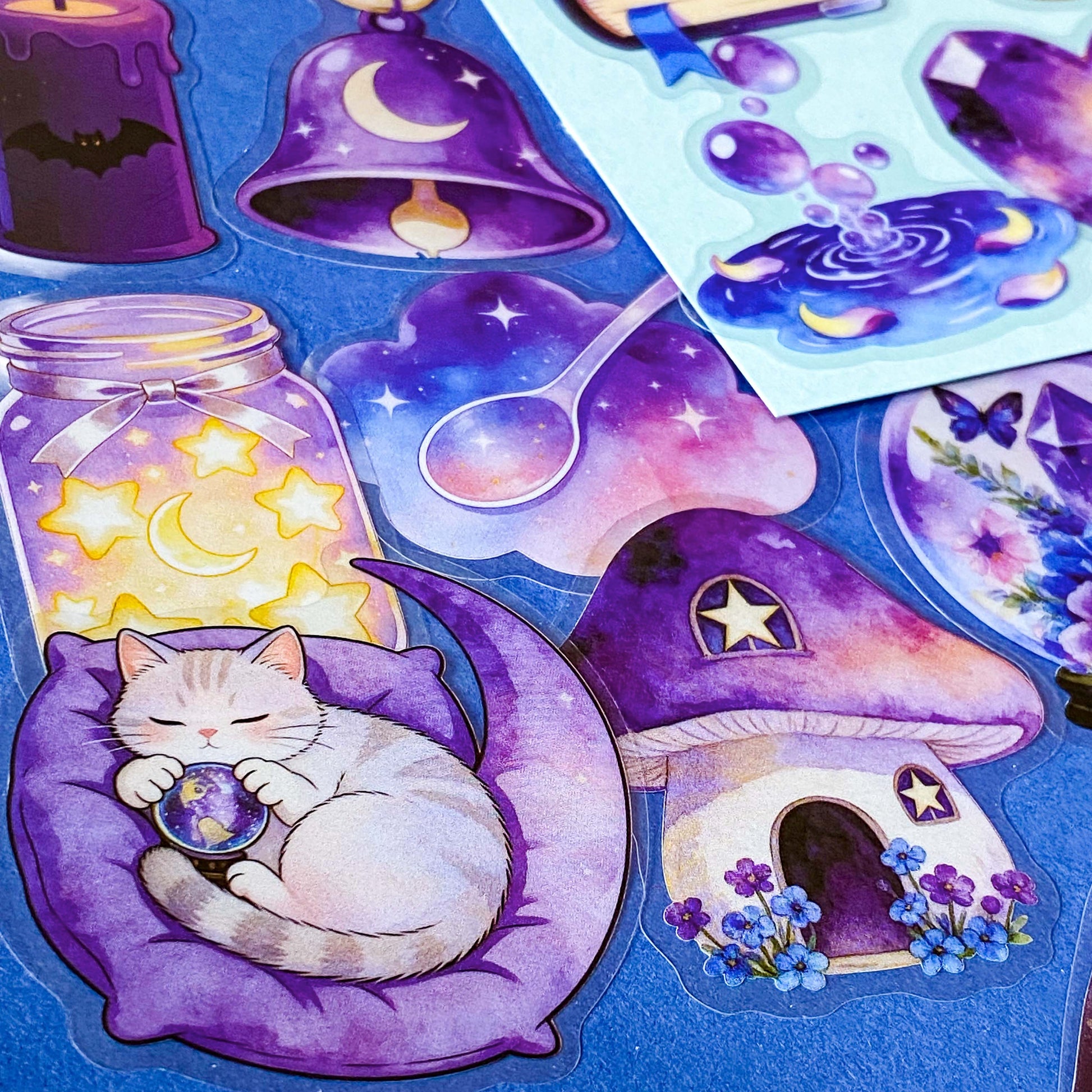pack of 50 magical fantasy stickers featuring crystal balls, spell books, moonlit scrolls, enchanted mushrooms, ravens, potion bottles, celestial moons, magical animals and crystal gardens in lavender, violet and blue tones. UK stationery shop and letterbox gifts store.