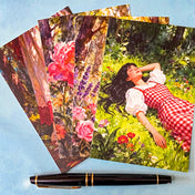 set of 4 cottage garden postcards featuring floral artwork, a girl in a garden, wrapped by a kraft belly band and wax seal sticker on a blue background