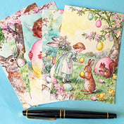 vintage storybook postcard set of 5 featuring a girl with rabbits and pastel eggs in a spring garden on a blue background