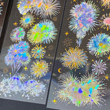 three transparent holographic firework sticker sheets with celestial stars, moons and iridescent rainbow foil effects