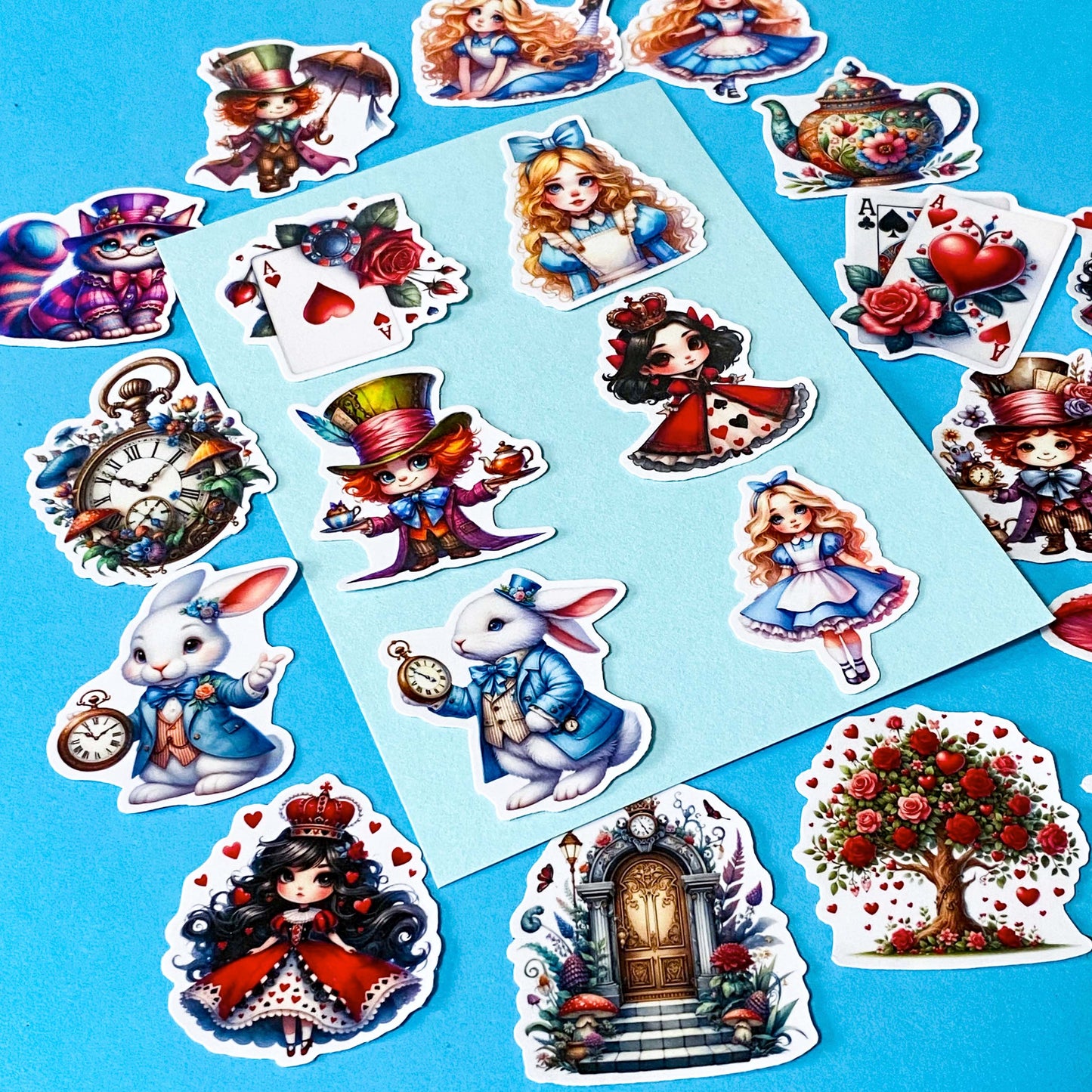 alice in wonderland inspired vinyl satin sticker set of 20 with cute kawaii illustrations featuring mad hatter, cartoon style red queen of hearts, pocket watch, white rabbit, cheshire cat, alice and playing card designs. UK cute stationery and sticker shop.