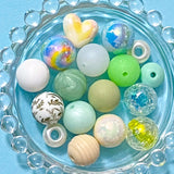 Assorted colorful beads on a blue plate with a bubblegum bubble border.