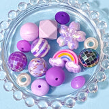 purple and lilac large acrylic and silicone beads bundle on a blue plate