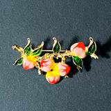 Decorative brooch with peaches design on a dark background