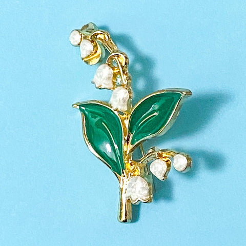 lily of the valley Brooch with green leaves and white flowers on a blue background